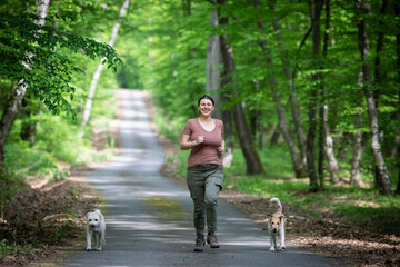 happy woman with her dogs in the forest