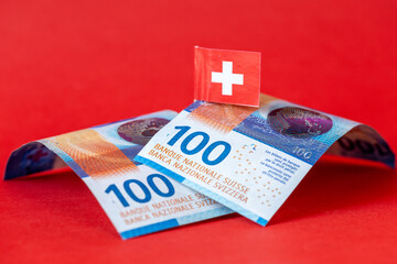 Switzerland finance, Business concept, Swiss franc banknotes with Switzerland flag on beautiful red background
