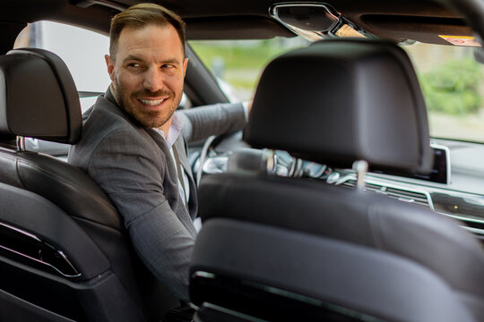 Welcoming smile from a joyful driver in a luxury sedan on a sunny day