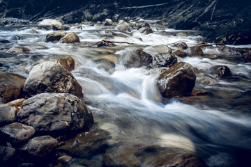 A river with a rocky bottom and a stormy current.