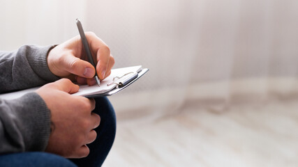 Psychological therapy. Depressed woman talking to her psychologist, doctor making notes in notepad,...