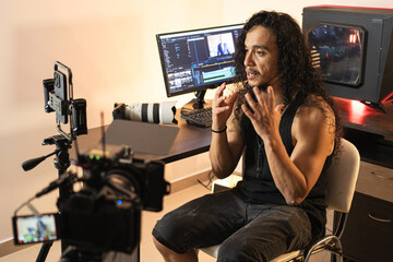 Technology-Driven Video Production. A long-haired content creator immersed in his studio, recording...