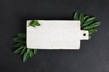 Mint leaves served on ceramic kitchen board on black rustic table, ingredient for summer cocktails and lemonade, top view