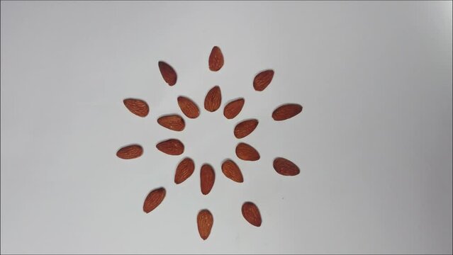 Almond (badaam) with Artistic arrangement isolated on white background - health care concept