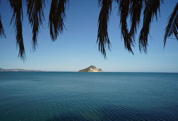 beach and shore of Limni Keriou and Marathonisi island with palm trees leaves