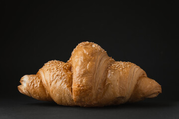 Close up shot of freshly baked croissant on the black background. Traditional french pastry