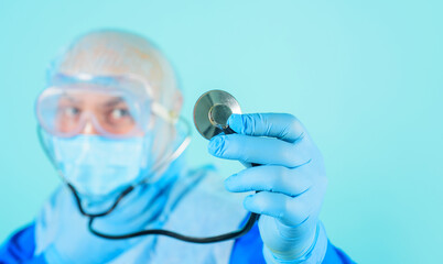 Healthcare and medicine. Closeup of doctor's hand in blue glove with stethoscope. Selective focus....