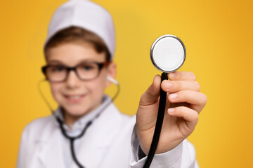Little friendly doctor ready to examine you, cute boy wearing medical uniform holding stethoscope