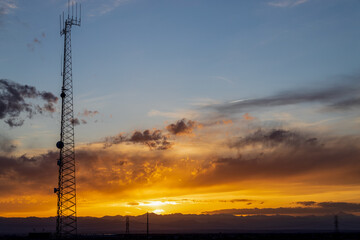 Sunset sky in the spring over the suburban neighborhood in Aurora, Colorado, with a communication tower in the foreground