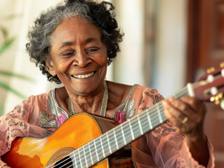 Closeup portrait of a senior black woman playing the acoustic guitar with a smile.  Shallow dof.