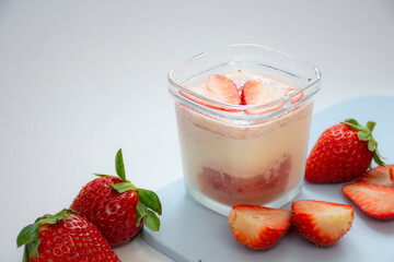 A homemade natural yogurt with fresh red strawberries on a cutting board