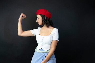 A woman in a red hat and white shirt is flexing her arm