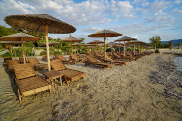 wooden sun beds and parasols on Alikanas  sand beach