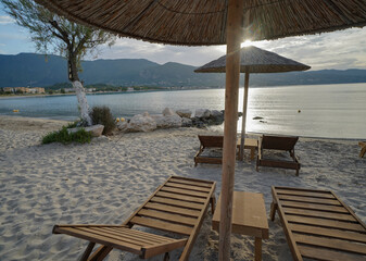 wooden sun beds and parasols on Alikanas beach
