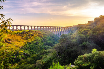 Aqueduct between mountains at sunrise with cloudy sky in arcos del sitio in tepotzotlan state of...