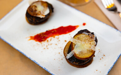 Appetizing timbale with fried morcilla, potatoes, caramelized pear slices and cheese served in...