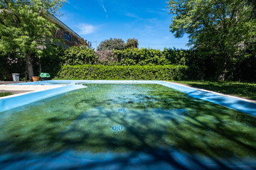 A swimming pool of a villa has been covered for the winter and has accumulated rainwater and...