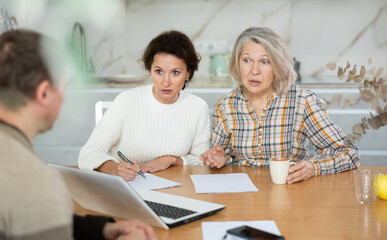 Mother and daughter considering offer from agent, asking questions and signing papers