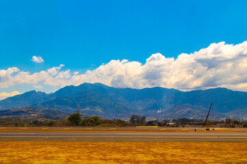 Runway airport city mountains panorama view from airplane Costa Rica.