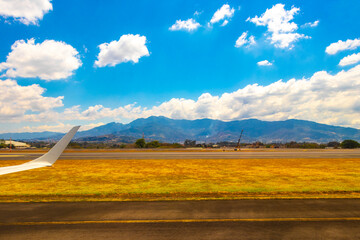 Runway airport city mountains panorama view from airplane Costa Rica.