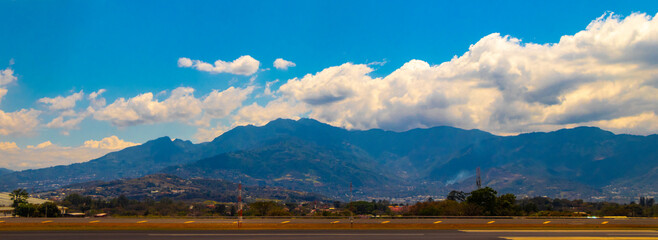 Runway airport city mountains panorama view from airplane Costa Rica.