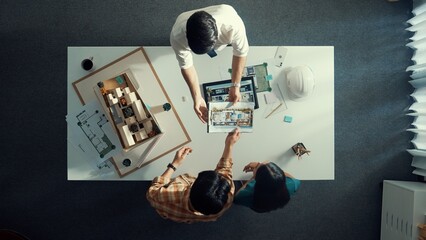 Top down view of civil architect looking at project plan while present to investor at meeting...