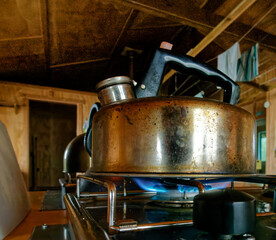 A kettle boiling water on a gas hob. Now we're cooking with gas.