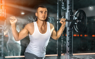 Sporty man performing set of exercises with barbell during intense workout. Concept of weight...