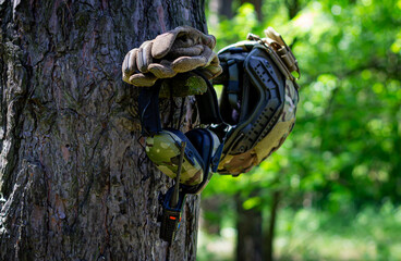 Military equipment on a tree while resting. Walkie-talkie, active tactical headphones, assault...