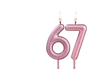 Lit birthday candle - Candle number 67 on white background