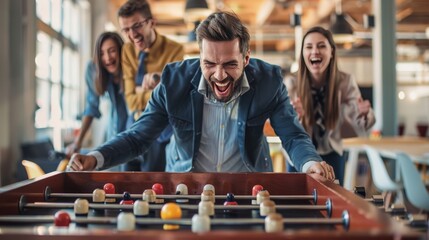 A business team taking a break from work to play a game of foosball, their faces filled with...