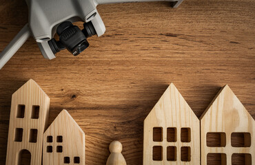 Drone on a table with wooden houses Drone surveillance concept, Uav in urban environments,...