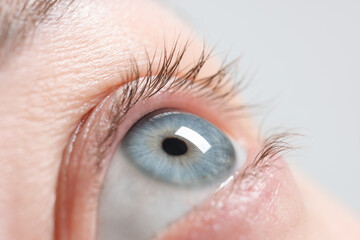 Obraz premium Macro photo of woman with beautiful eyes on light background