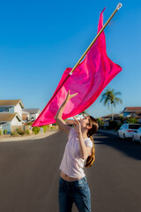 Student Catching Tall Flag on Clear Day, La Palma, California, USA, vertical