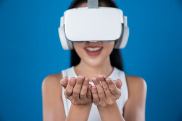 Smart female standing with blue background wearing VR headset connecting metaverse, futuristic...