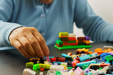 A person is playing with a pile of plastic blocks