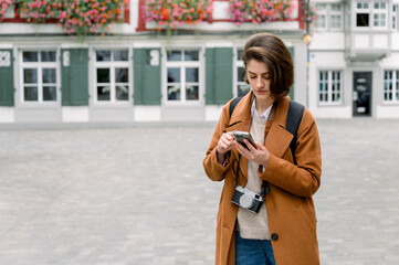 Young woman using mobile while exploring a city