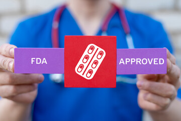 Doctor holding styrofoam blocks with drug icon sees inscription: FDA APPROVED. FDA Food and Drug...