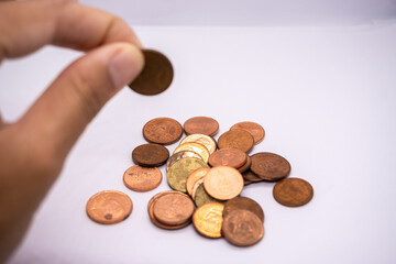 Hand holding coins for home budget planning, saving money, and business growth in the context of currency, economics, work, jobs, tasks, fairs, services, and the stock market