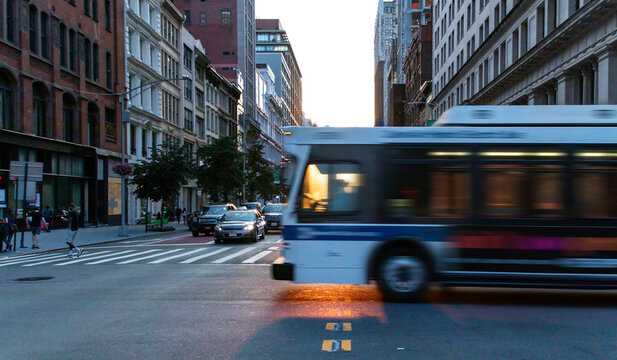 Sunlight shining through a city bus as it's driving down the street on 5th Avenue in New York City with motion blur effect