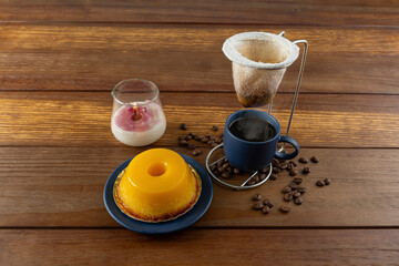 Small quindim, traditional Brazilian sweet, next to a cup of coffee and a candle_1.