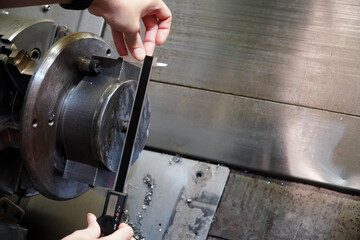 Device for measuring the thickness of a metal product,Worker is measuring to the thickness of...