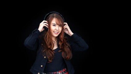 Portrait of young asian woman putting headphone on isolated on black background for song and audio voice record for music and entertainment business