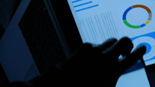 Vertical video. Office fraud. Data theft. Man hands taking photo of corporate confidential project information business statistics on smartphone late at night at workplace laptop.