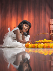 Pretty young girl making Pookalam with fresh flowers, Happy Onam background