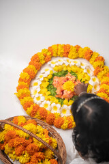 Happy Onam background Little girl making Onam Pookalam with fresh flowers