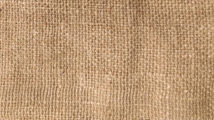 Close-up of fabric woven from burlap. Color photo of the texture of a brown burlap potato sack.