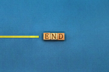 黄色いテープのラインがENDの英語ブロックで止められた青色の背景