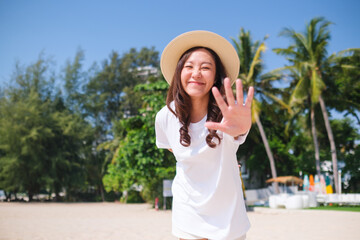 Portrait image of a happy woman outstretched hand while walking on the beach
