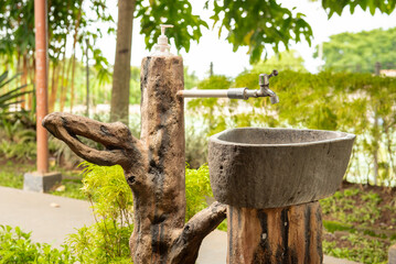 The stone sink for washing hands, which is arranged with natural decorations such as wood and...